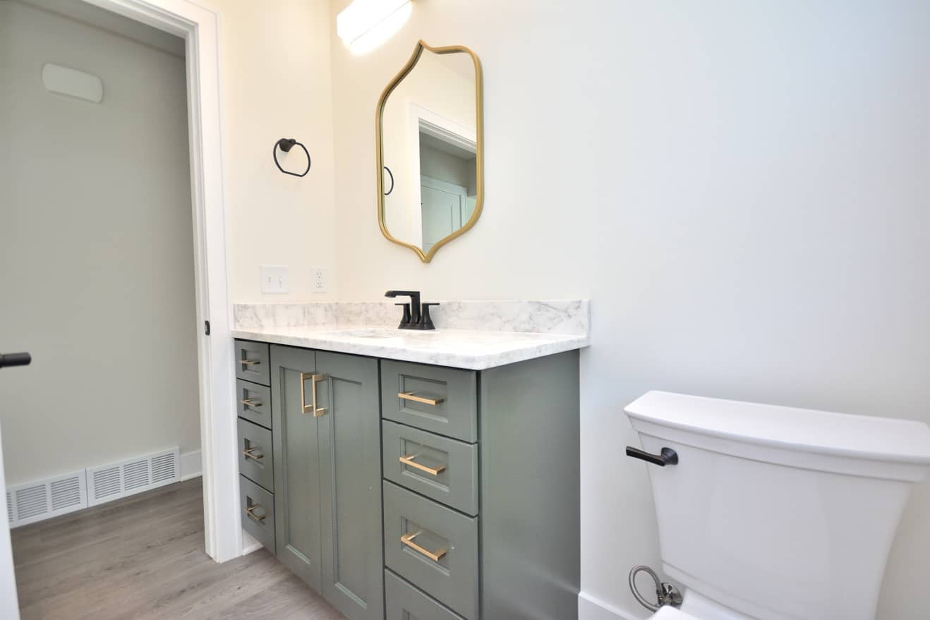 complete bathroom remodel with new mirror, toilet, and cabinets